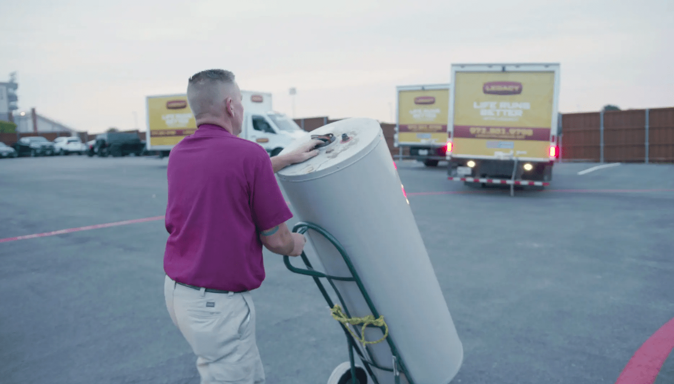 Plumber from Legacy Plumbing delivering a water heater to be installed