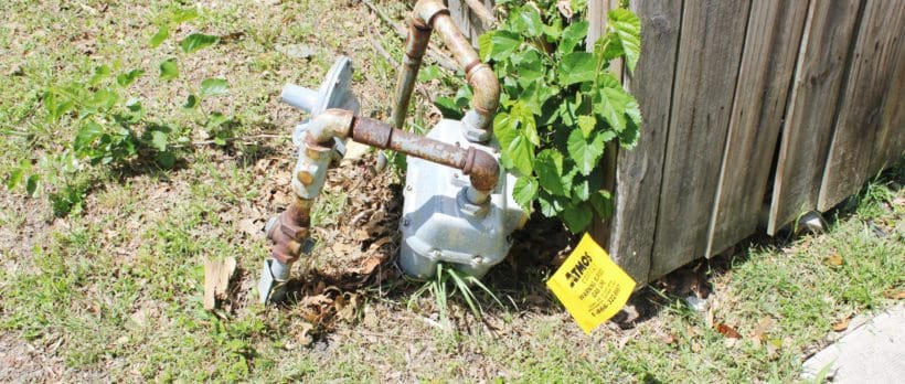 image of a run down atmos gas meter in the backyard